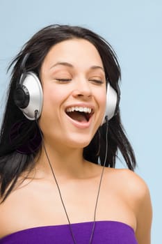 Close-up of a young woman wearing headphones and listening to music