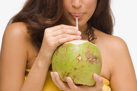 Close-up of a young woman drinking coconut milk