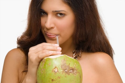 Portrait of a young woman drinking coconut milk