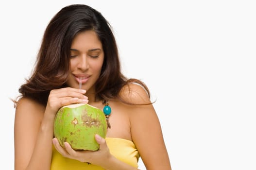 Close-up of a young woman drinking coconut milk