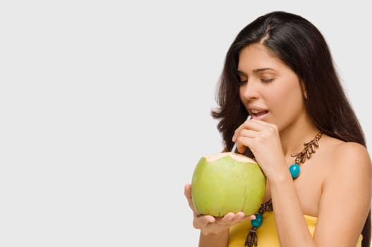 Close-up of a young woman drinking coconut milk