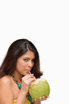 Portrait of a young woman drinking coconut milk