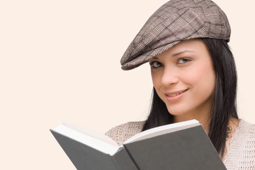 Portrait of a young woman smiling with a book in front of her
