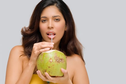 Portrait of a young woman drinking coconut milk