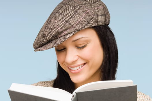 Close-up of a young woman reading a book and smiling