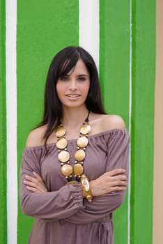 Portrait of a young woman standing with her arms crossed and smiling