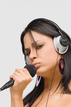 Portrait of a young woman singing into a microphone
