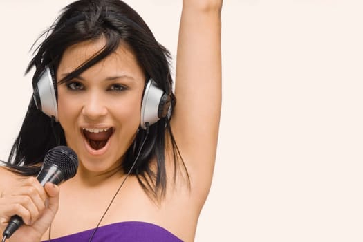 Portrait of a young woman singing into a microphone