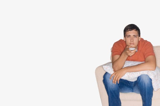 Portrait of a young man sitting on a couch and watching television