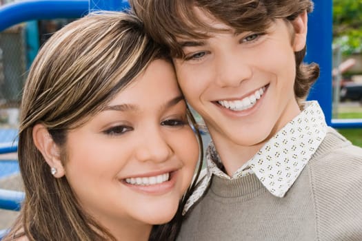 Close-up of a young woman and a teenage boy smiling