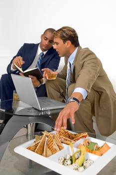Two businessmen sitting on a couch and having a discussion