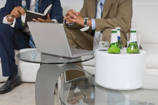 Two businessmen sitting on a couch and having a discussion