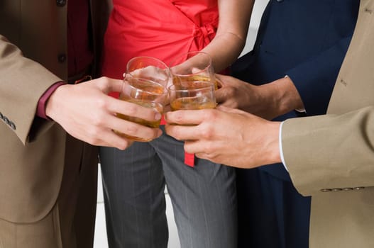 Mid section view of four business executives toasting with wine glasses in a party