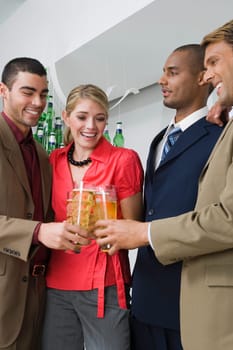 Four business executives toasting with glasses of beer in a party