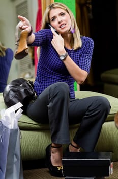Young woman in a shoe store talking on a mobile phone