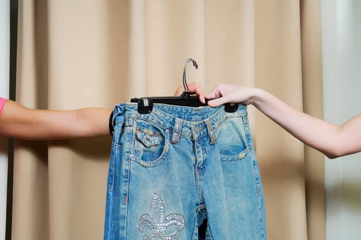 Sales clerk giving a jeans to a customer's hand
