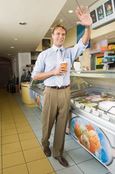Businessman waving in an office cafeteria