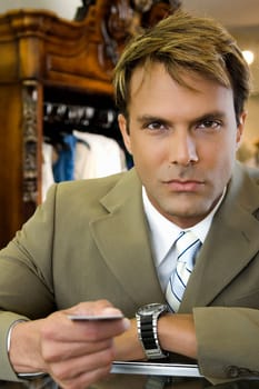Portrait of a businessman holding a credit card at a cash counter