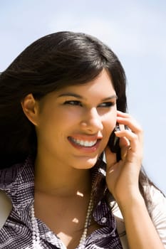 Close-up of a young woman talking on a mobile phone and smiling