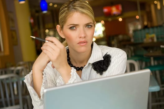 Portrait of a businesswoman sitting in front of a laptop in a restaurant