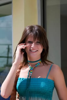 Portrait of a young woman talking on a mobile phone and smiling