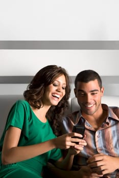 Young couple using a mobile phone and smiling