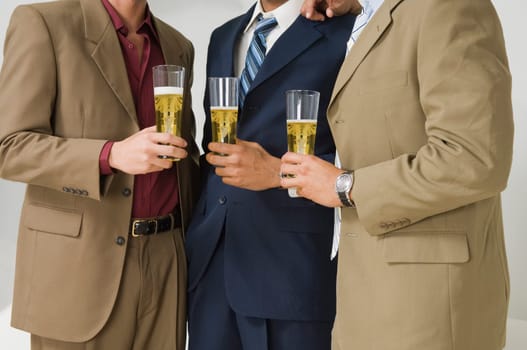 Three businessmen holding glasses of beer