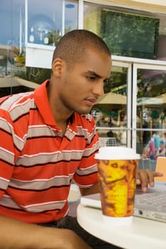 Young man using a laptop in a restaurant