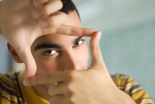 Portrait of a young man making a finger frame