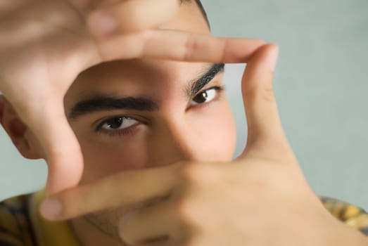 Portrait of a young man making a finger frame
