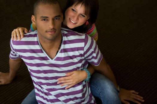 Young woman embracing a young man from behind and smiling