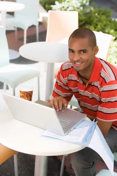 Portrait of a young man using a laptop in a cafe