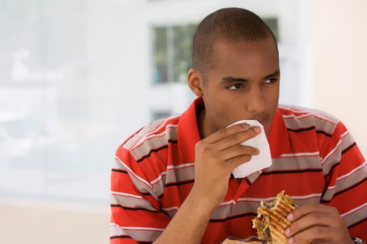 Close-up of a young man wiping his mouth with a tissue paper