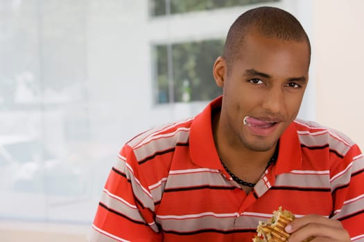 Portrait of a young man eating a sandwich