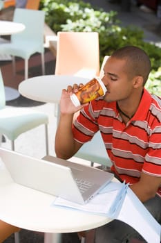 Young man sitting at a cafe and drinking coffee