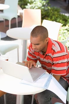 High angle view of a young man using a laptop in a cafe