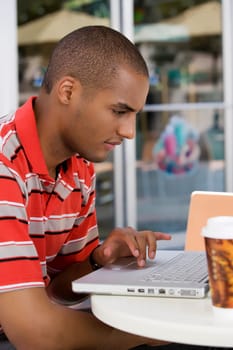 Young man using a laptop in a cafe