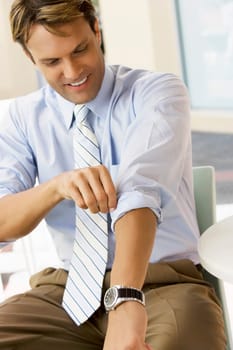 Businessman adjusting his sleeves and smiling