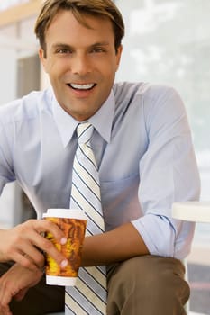 Portrait of a businessman holding a coffee cup and smiling