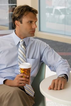 Businessman holding a coffee cup and thinking
