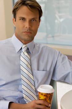 Portrait of a businessman holding a coffee cup in a cafe