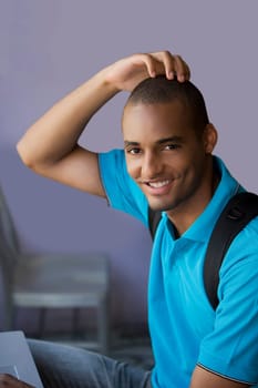 Portrait of a young man scratching his head and smiling
