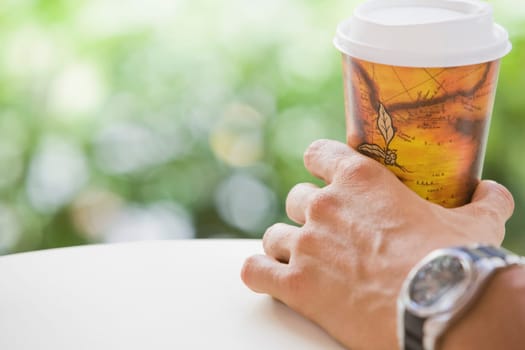 Close-up of a man's hand holding a disposable cup