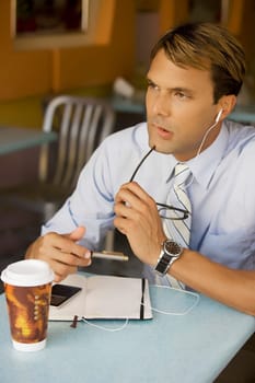 Businessman listening to an MP3 player and thinking
