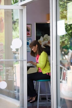 Side profile of a mature woman using a laptop in a cafe
