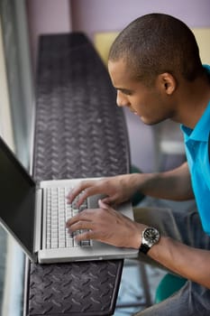High angle view of a young man using a laptop in a cafe