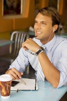 Businessman listening to an MP3 player and smiling