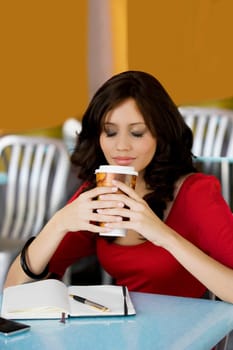 Young woman holding a cup of cold drink in a cafe