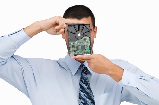 Close-up of a businessman holding a hard drive in front of his face