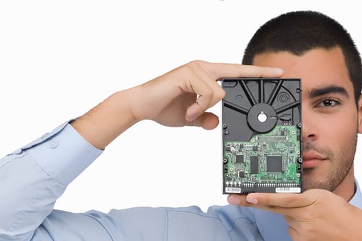 Portrait of a businessman holding a hard drive in front of his face